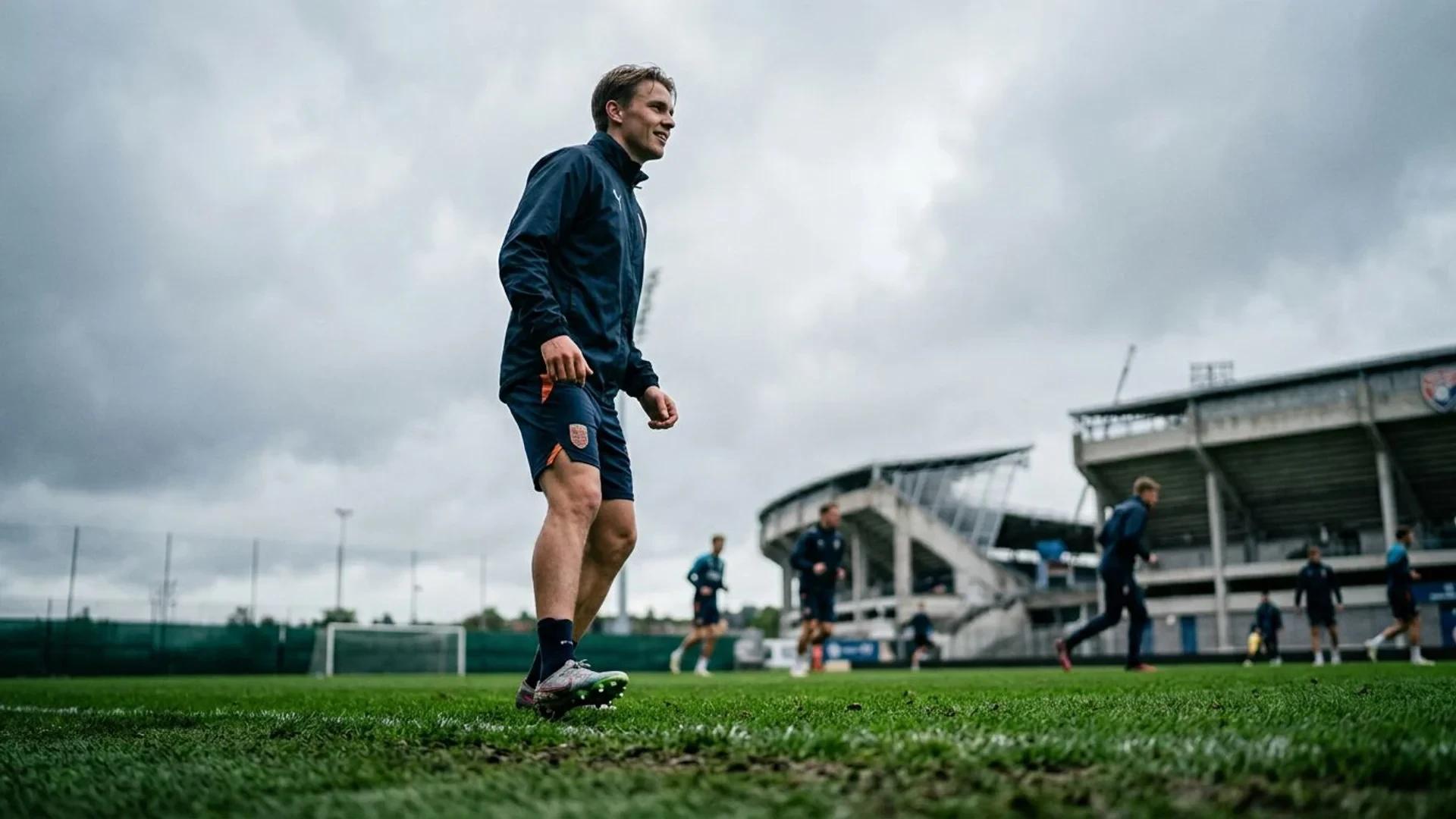 Teodor Haltvik standing on a football pitch, captured from a low angle under an overcast sky.