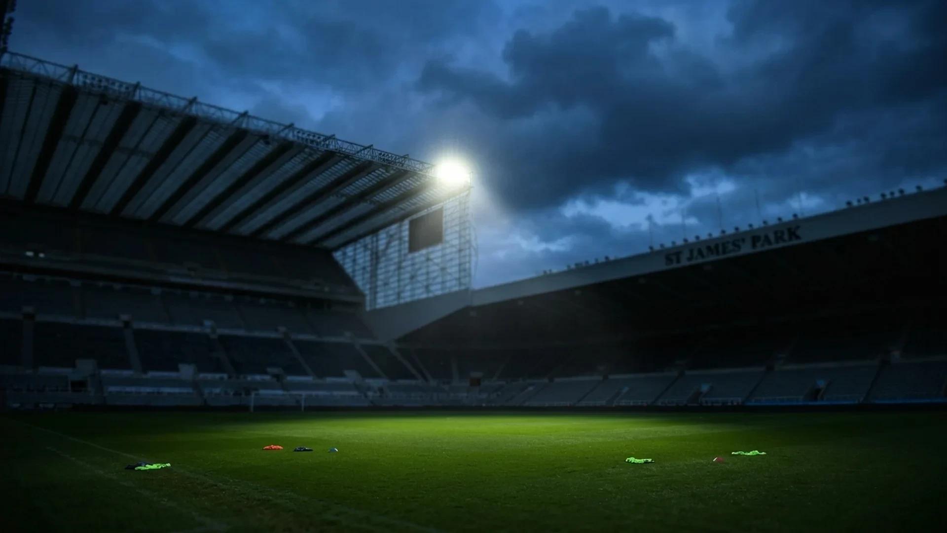 A low-angle view of an empty football pitch under a spotlight, symbolizing uncertainty in the club's future.