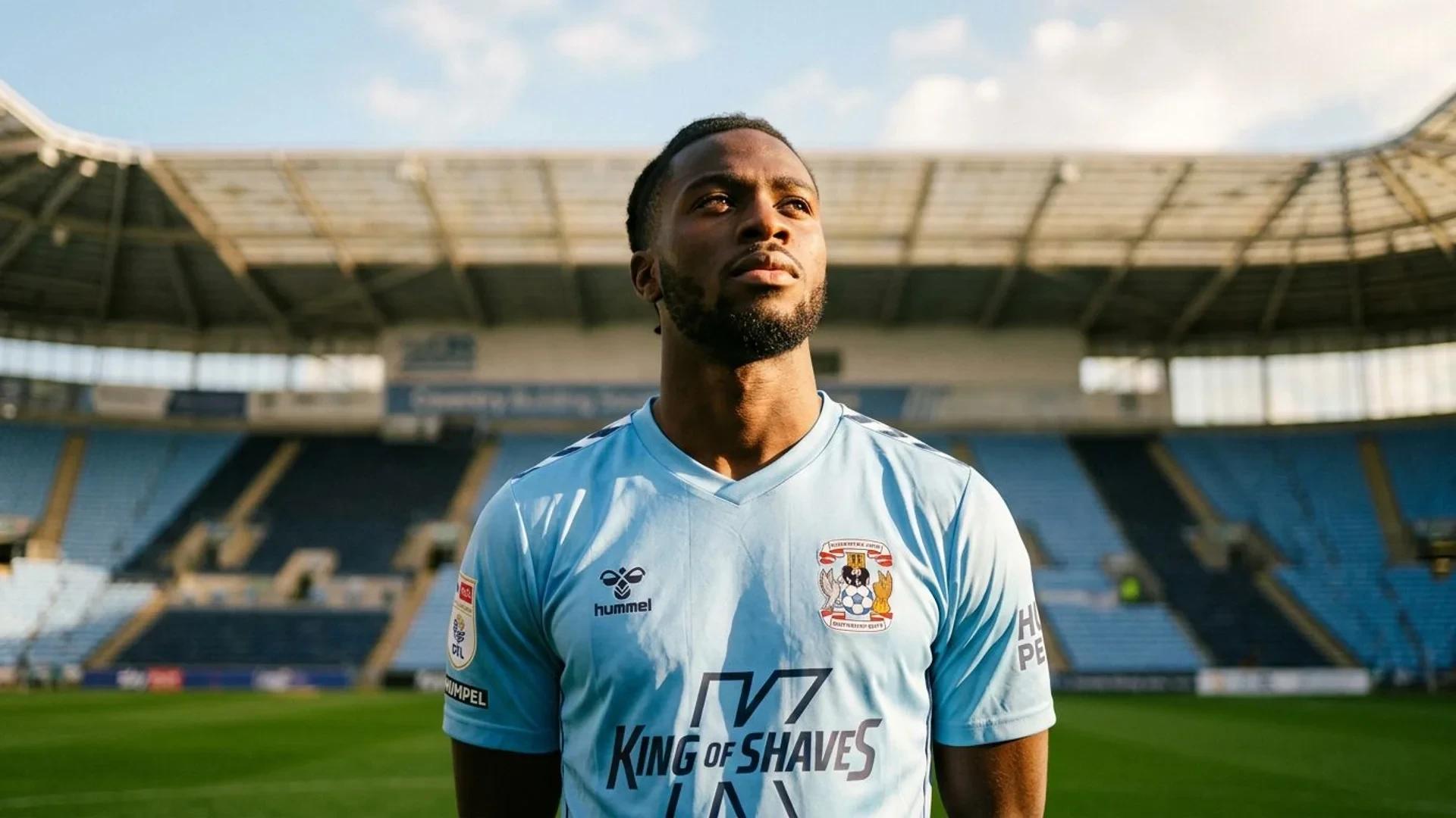 Loum Tchaouna in a Coventry City jersey standing on a football pitch, captured in a low-angle shot.