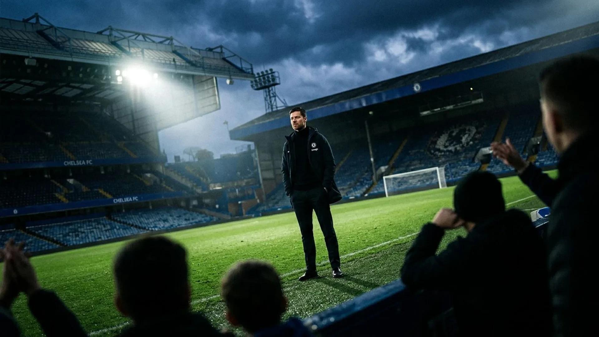 Xabi Alonso stands at Stamford Bridge, illuminated by a spotlight amidst a darkening sky.