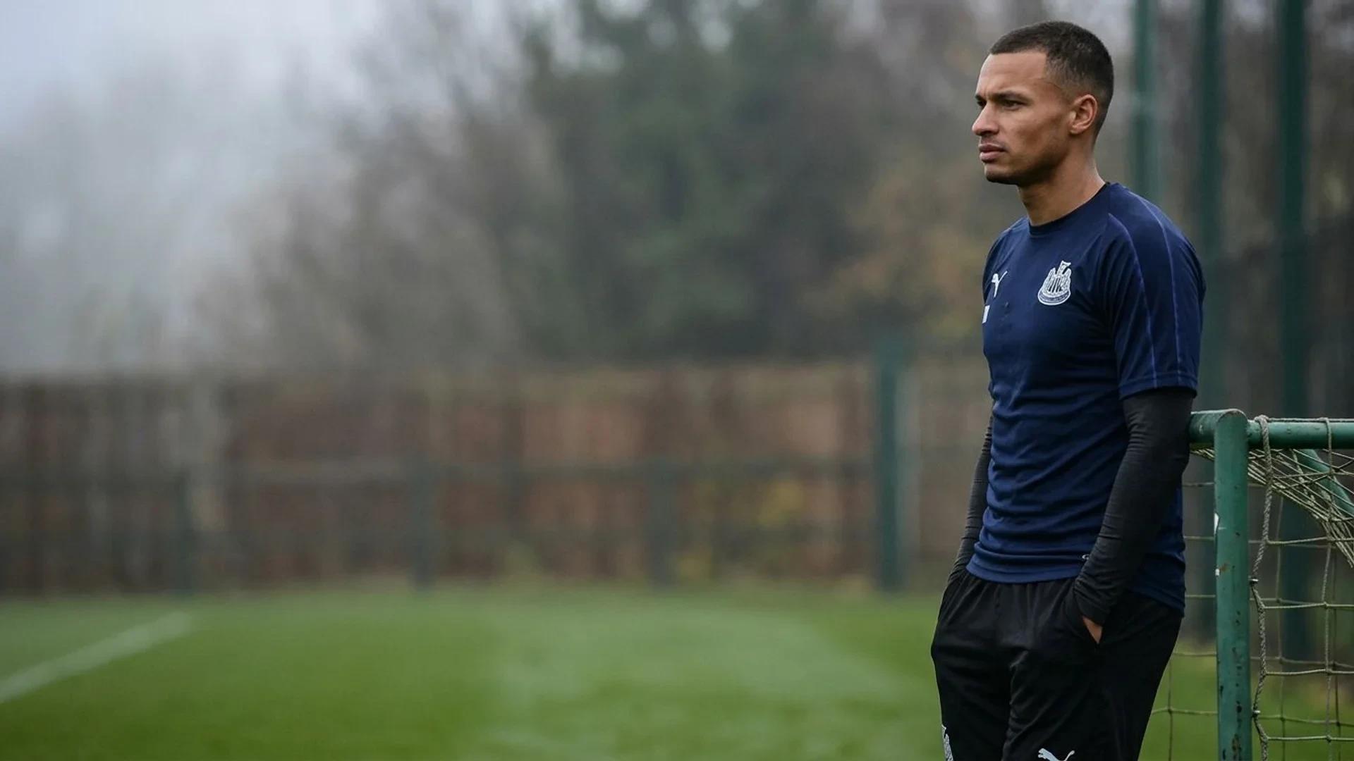 A contemplative Jacob Murphy stands on a practice pitch, bathed in soft overcast light.