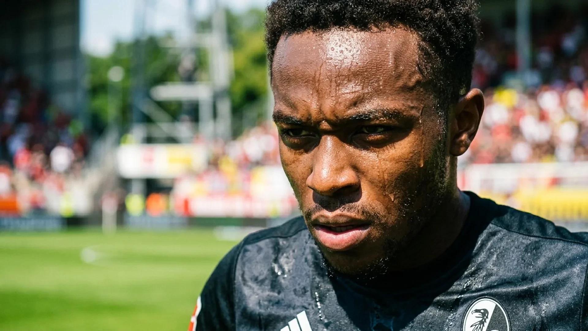 Close-up of a football player, Johan Manzambi, under bright sunlight, showing a focused expression.