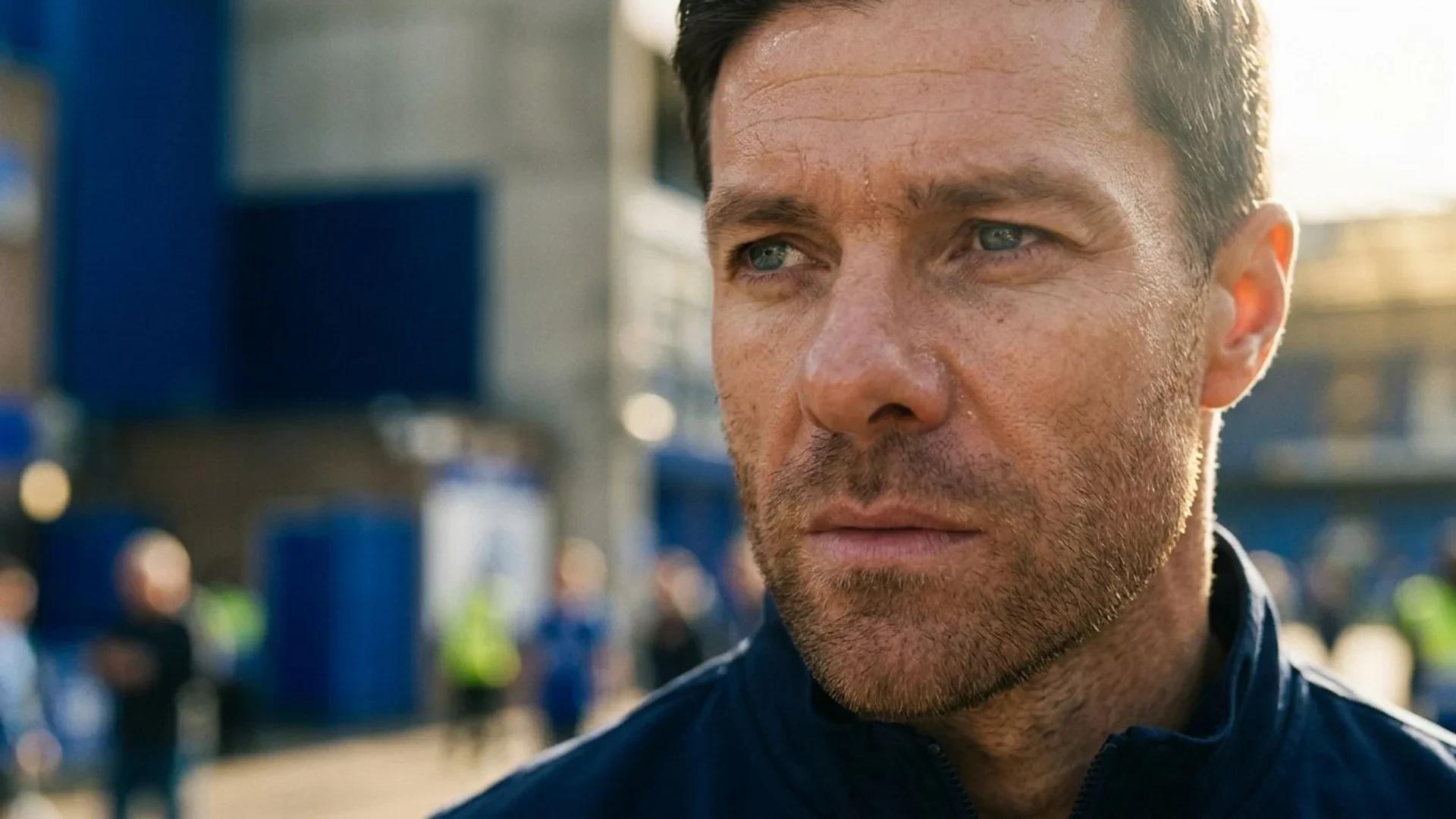 A close-up of Xabi Alonso's face under harsh sunlight, showing intense determination.