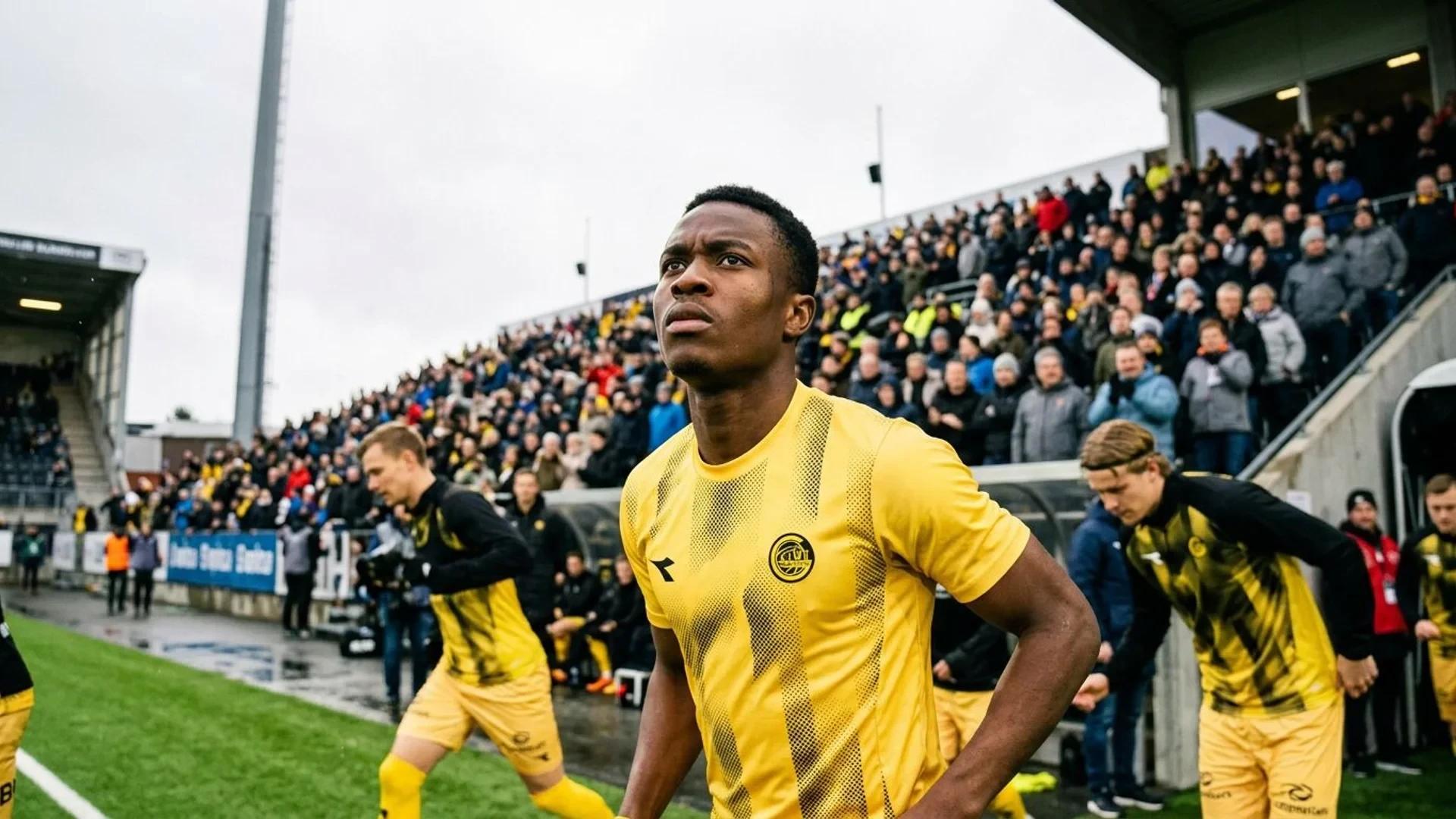 Joshua Kitolano in his Bodø/Glimt kit stands determined on the football field.