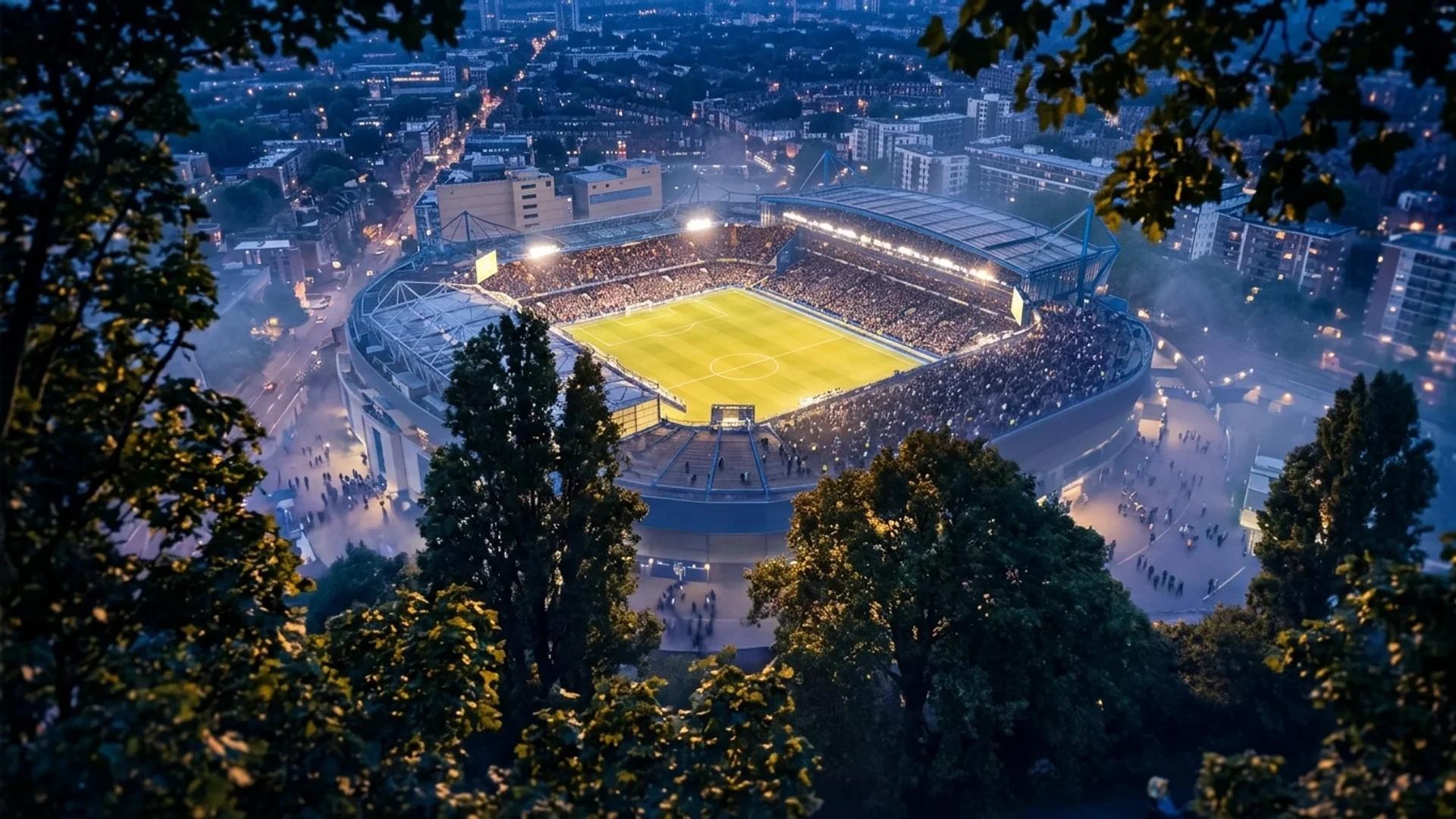 A bird's-eye view of Stamford Bridge at dusk, framed by trees.