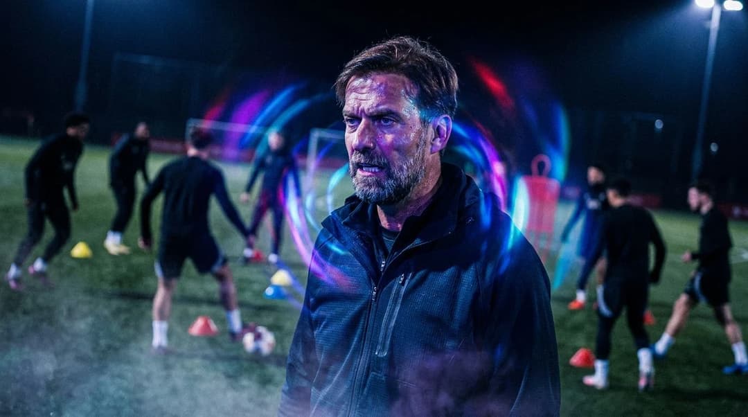Jürgen Klopp stands in a dimly lit training ground, illuminated by swirling neon lights.