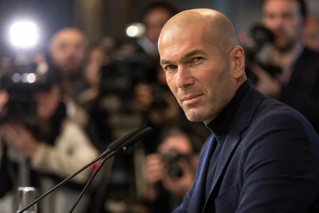 Zinédine Zidane stands at a press conference, looking determined as he discusses his new role.