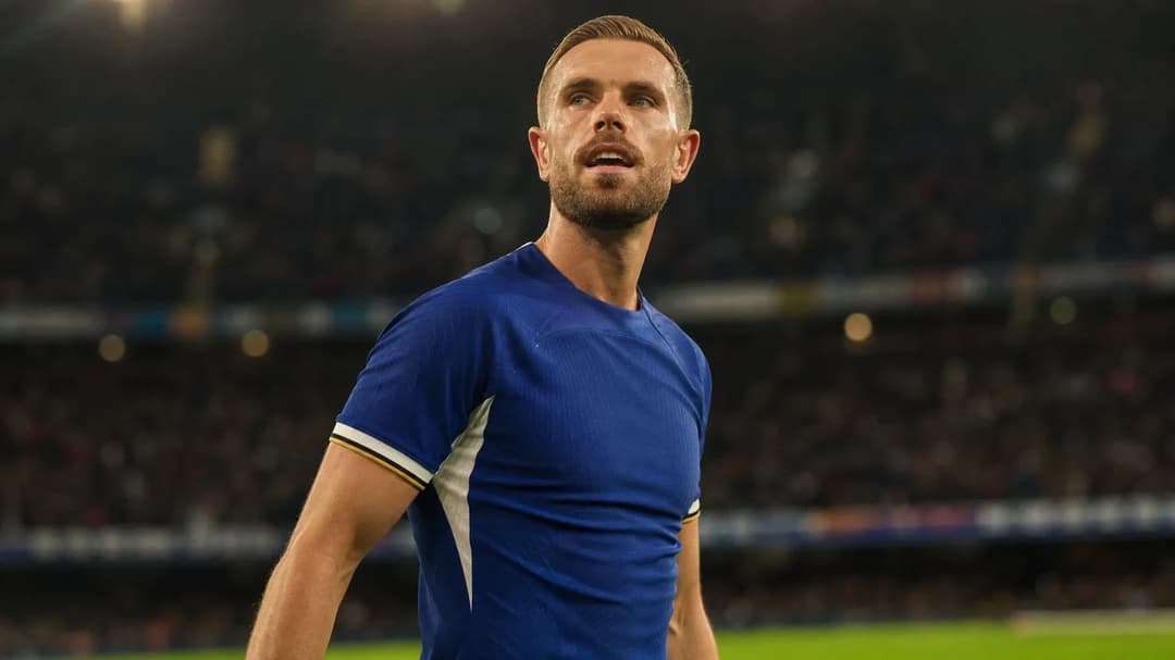 Jordan Henderson standing on the pitch with a focused expression.