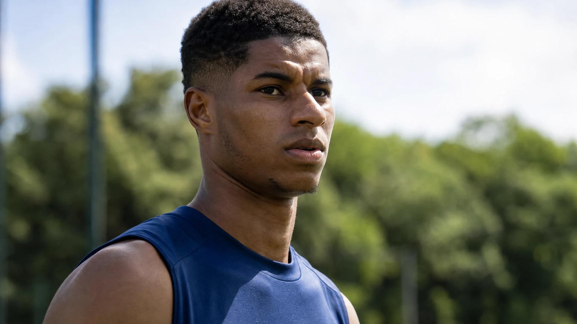 Close-up of Marcus Rashford in training, looking determined under bright sunlight.