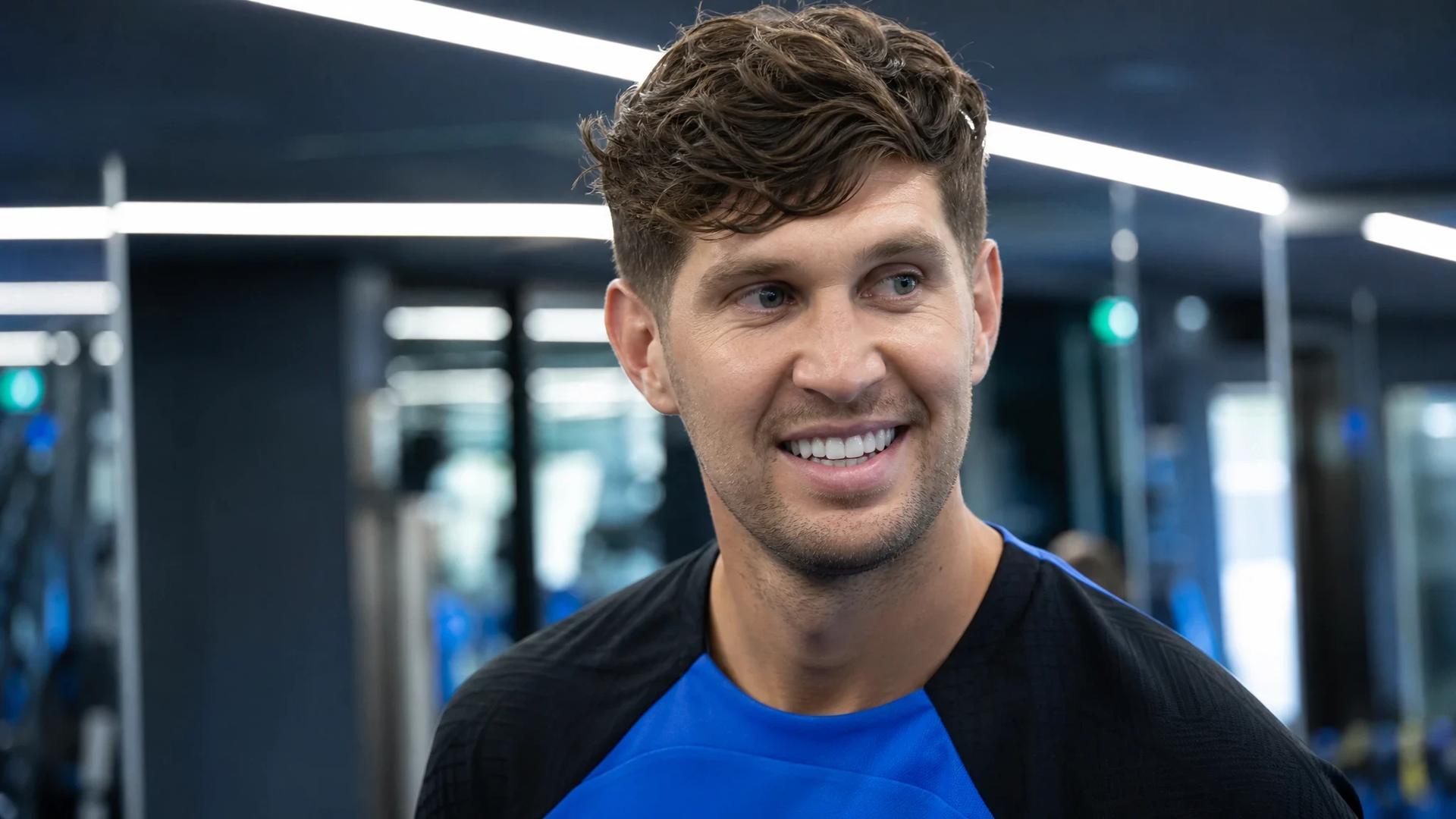 John Stones smiles at a training facility in Italy, ready for his new role at Inter Milan.