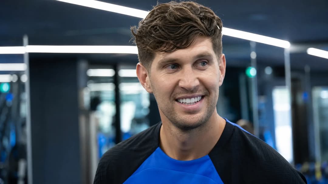 John Stones smiles at a training facility in Italy, ready for his new role at Inter Milan.