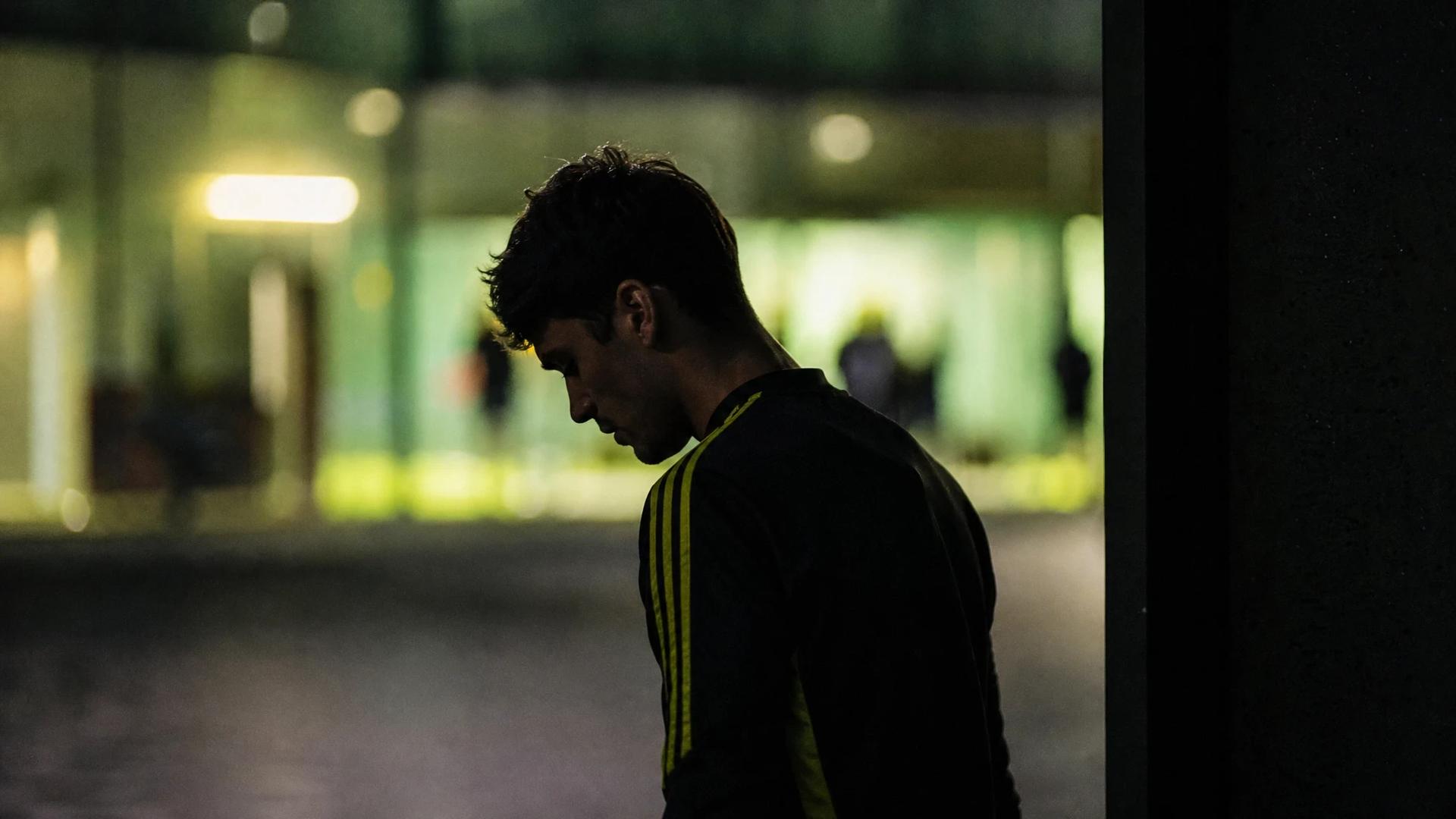 A silhouette of Giovanni Reyna in front of a softly glowing background at a training facility.