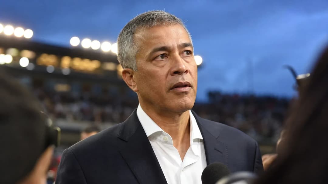 Carlos Cordeiro stands in front of a blurred crowd, expressing determination.