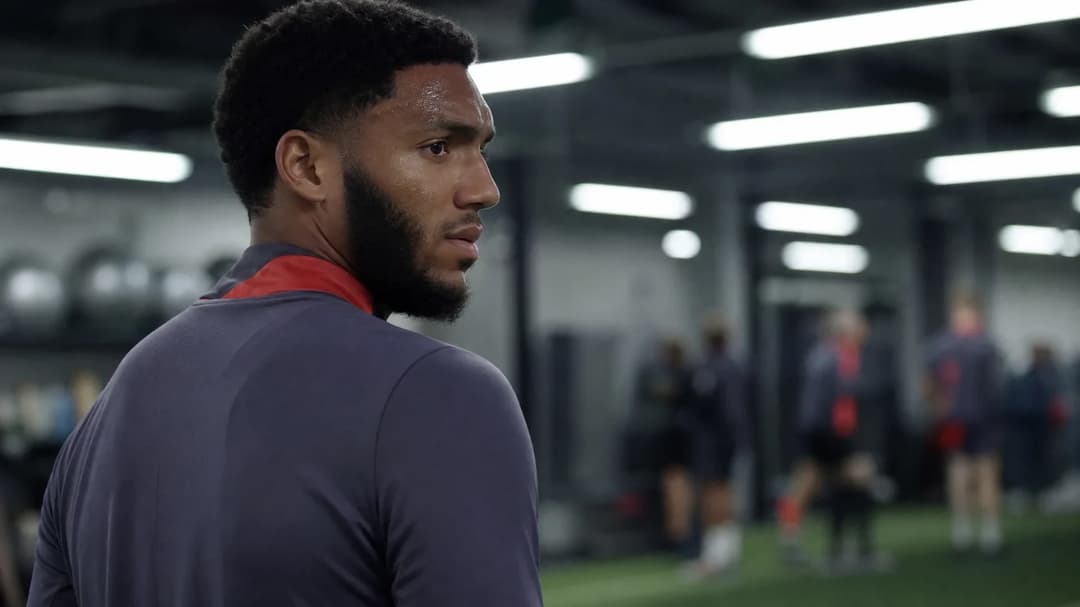 Joe Gomez stands in a training facility, reflecting on his injury amidst a blurred background.