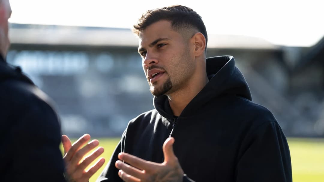 Bruno Guimaraes in a reflective moment at St James' Park, silhouetted against bright sunlight.
