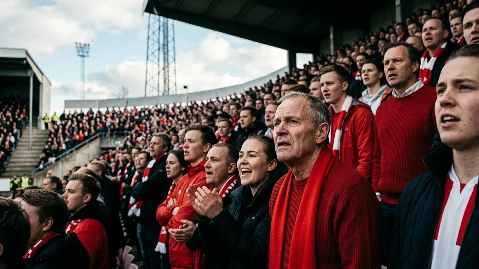 A low-angle shot capturing passionate football fans in anticipation at Fredrikstad Stadion.