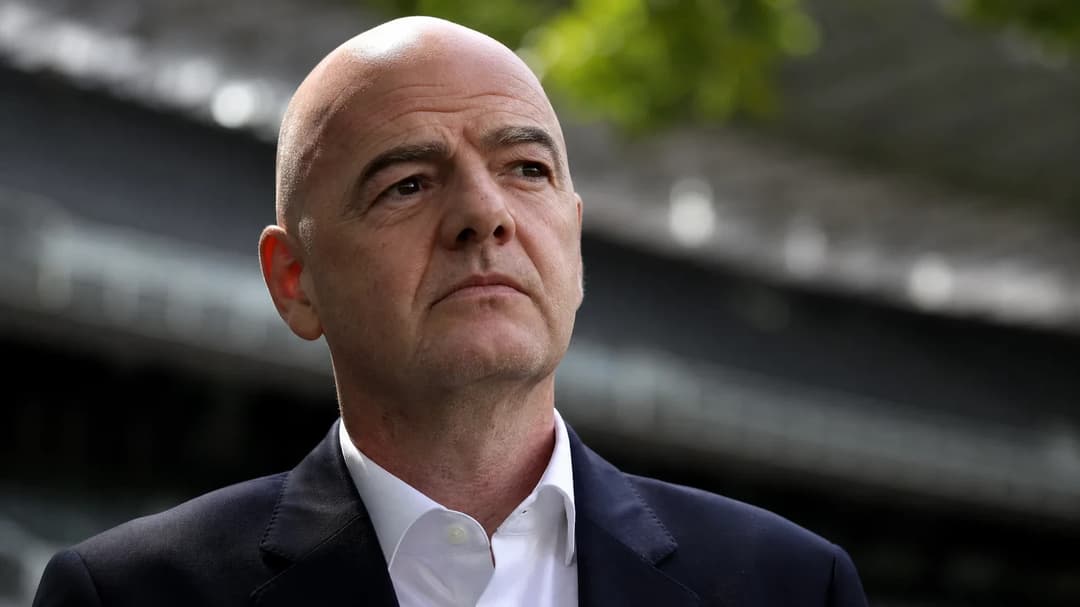 Close-up of FIFA president Gianni Infantino in a stadium setting, expressing determination.