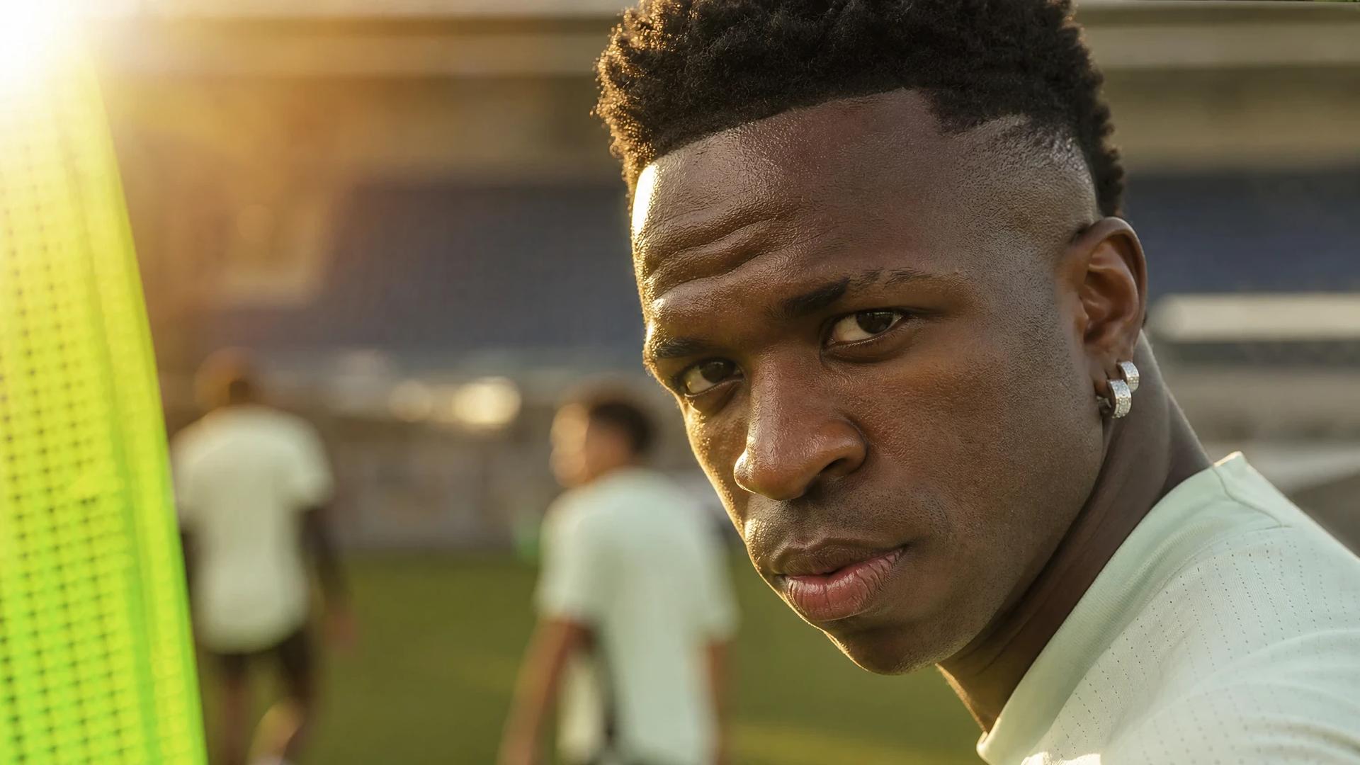 A close-up of Vinicius Jr. in training with golden-hour lighting highlighting his focused expression.