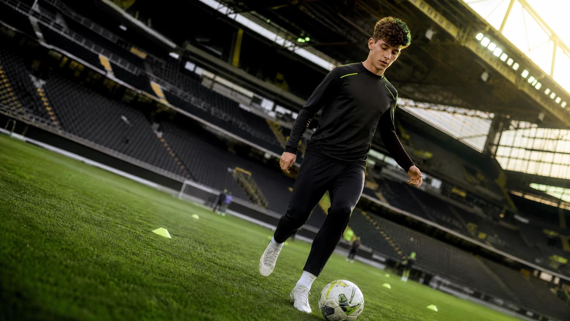 A young footballer named Konstantinos Karetsas practicing ball control during a training session at Signal Iduna Park.