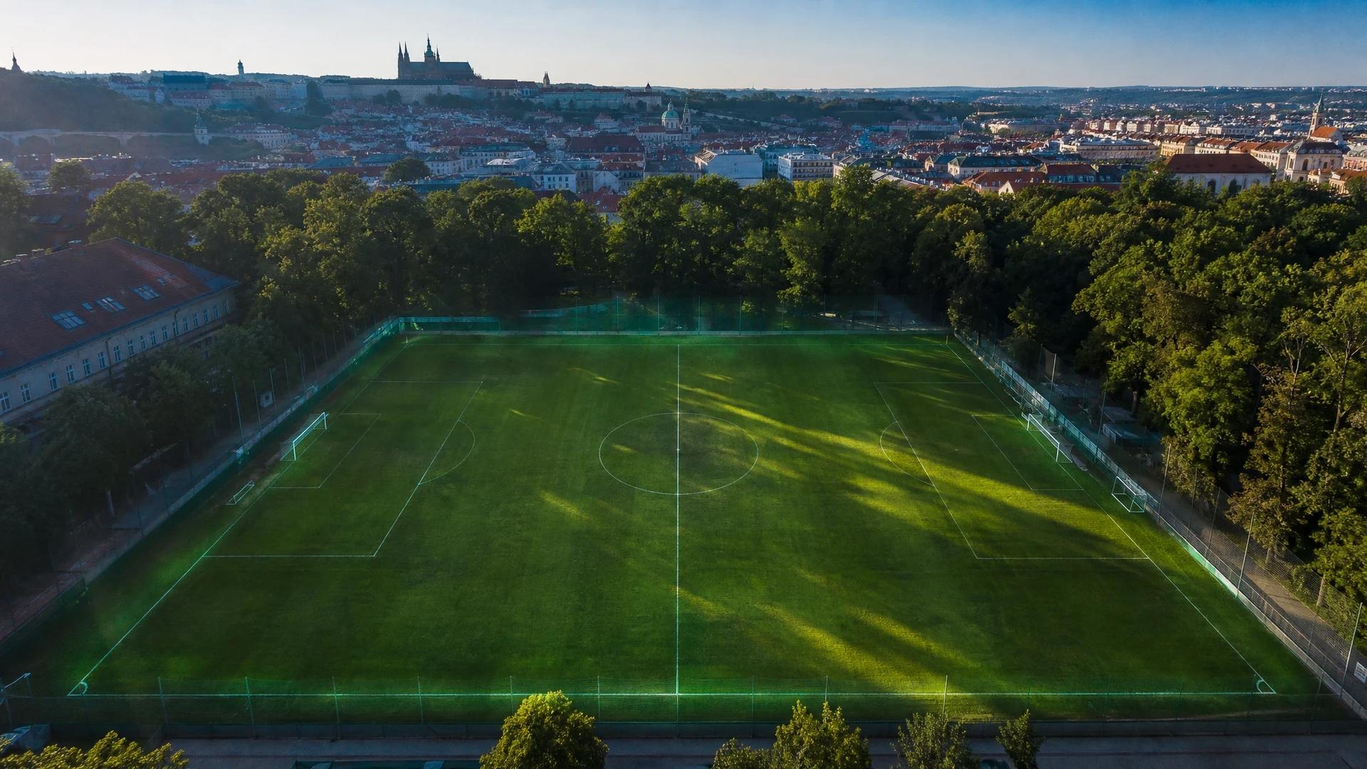 A bird's-eye view of a football pitch in Prague post-match, with dappled sunlight and a serene atmosphere.