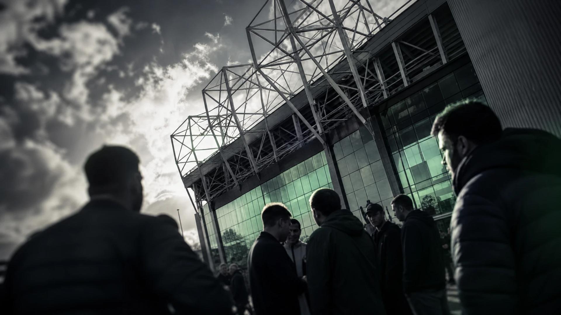 Dramatic shot of Old Trafford with fans discussing the upcoming season.