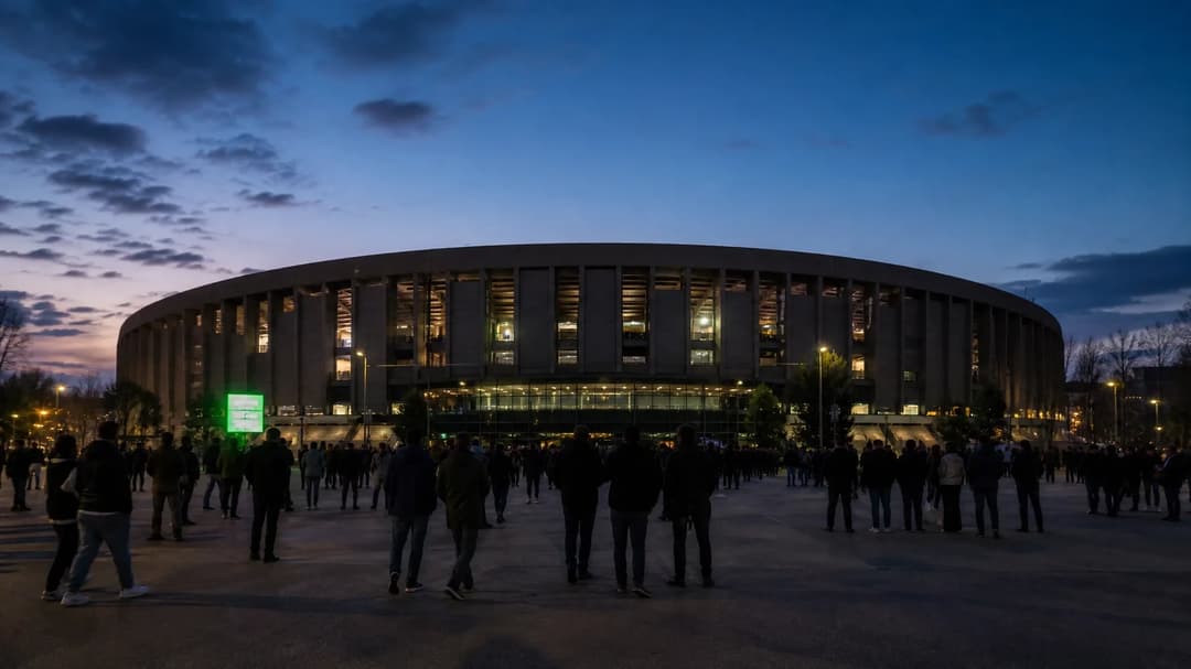 Wide-angle view of Camp Nou stadium at dusk with gathering fans.