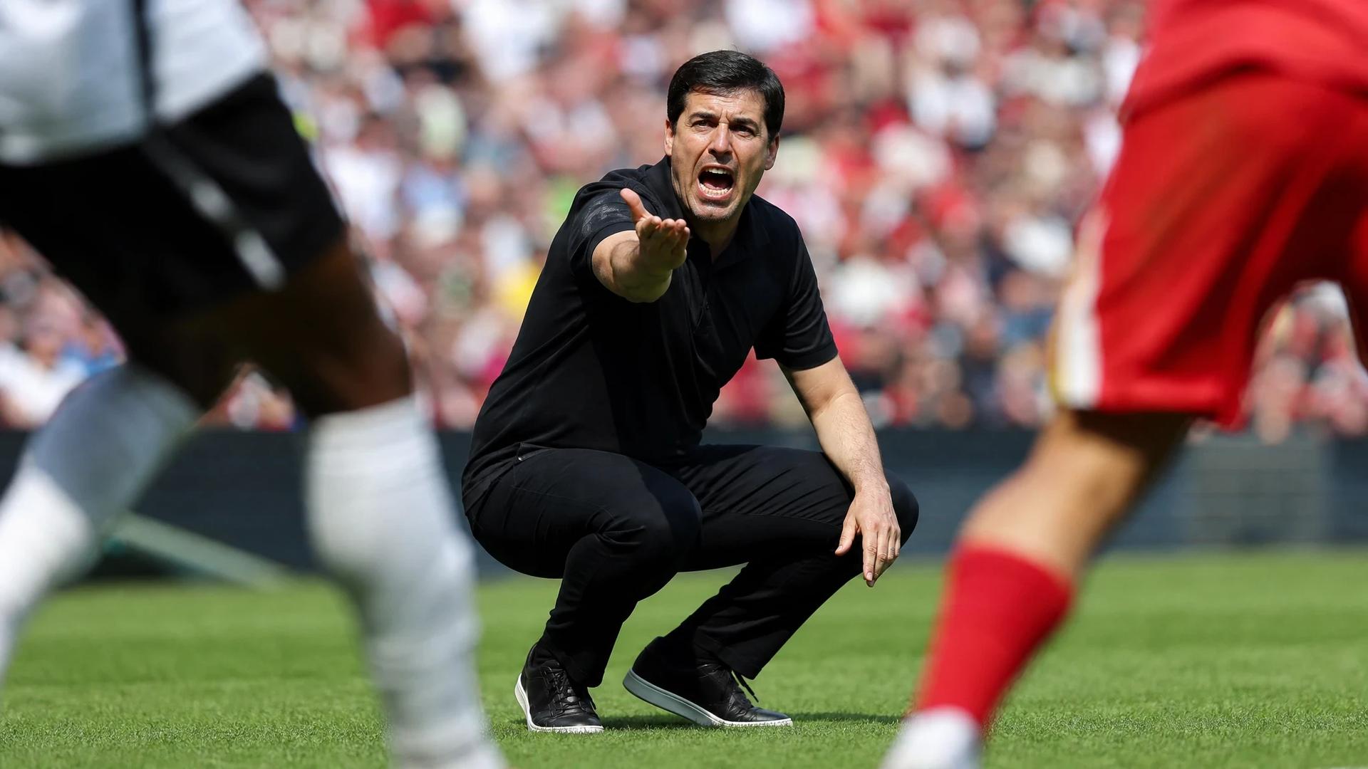 Liverpool manager Andoni Iraola passionately gestures during a football match.