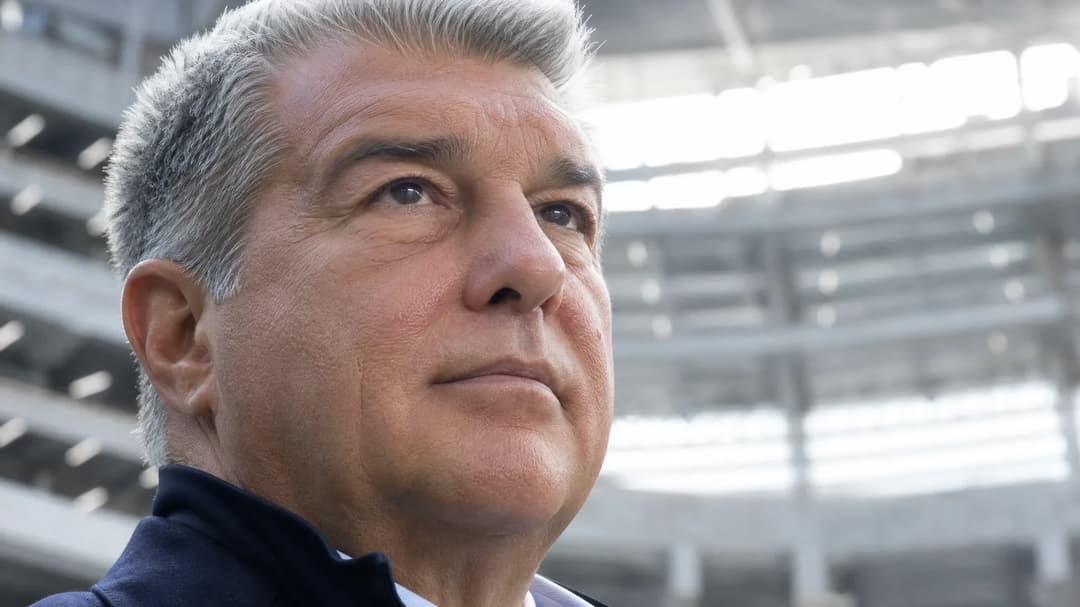 Close-up of Joan Laporta, president of FC Barcelona, illuminated by fluorescent lights in a modern setting.