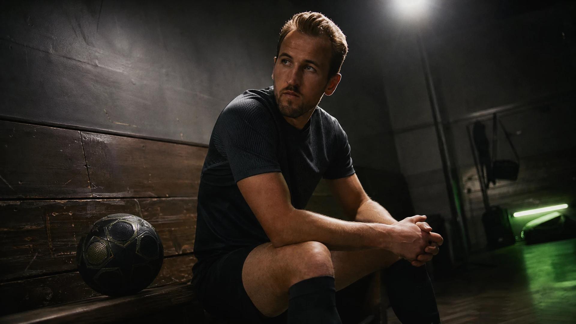 Harry Kane seated on a bench in a training room, deep in thought.