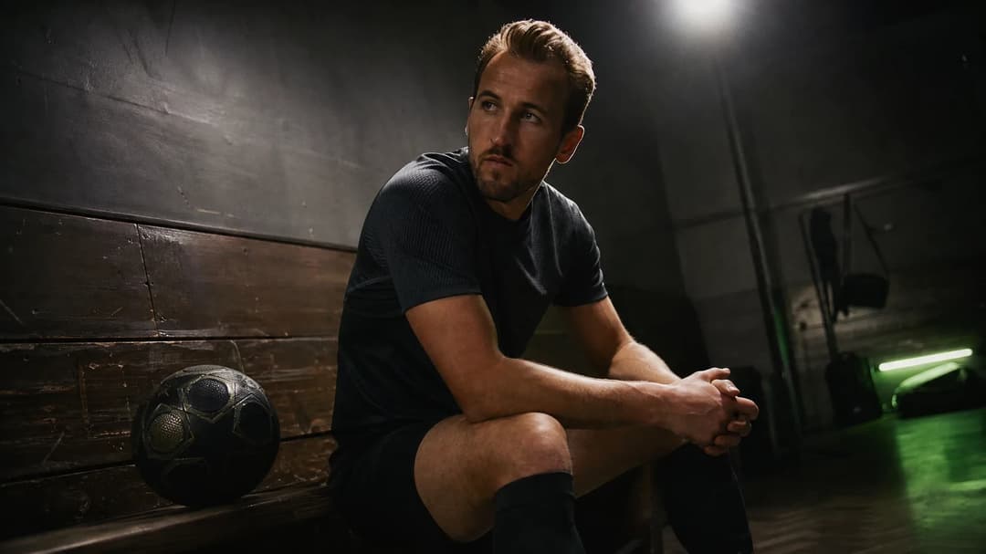 Harry Kane seated on a bench in a training room, deep in thought.