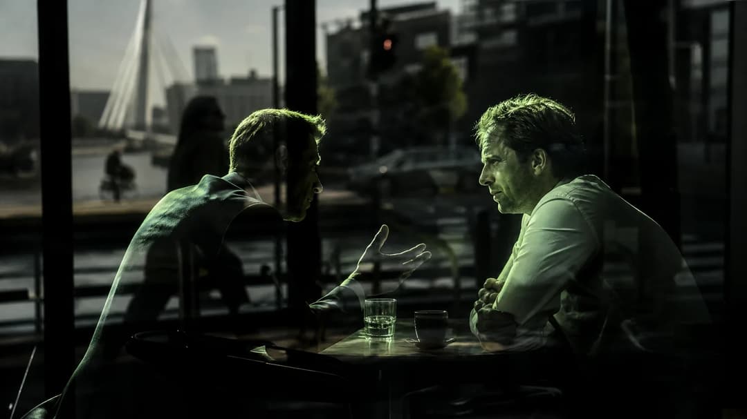Two individuals in conversation through a glass window, illuminated by harsh midday sunlight.