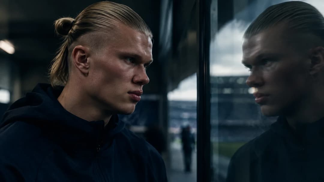Erling Haaland stands thoughtfully in a dimly lit corridor, reflecting on his future.