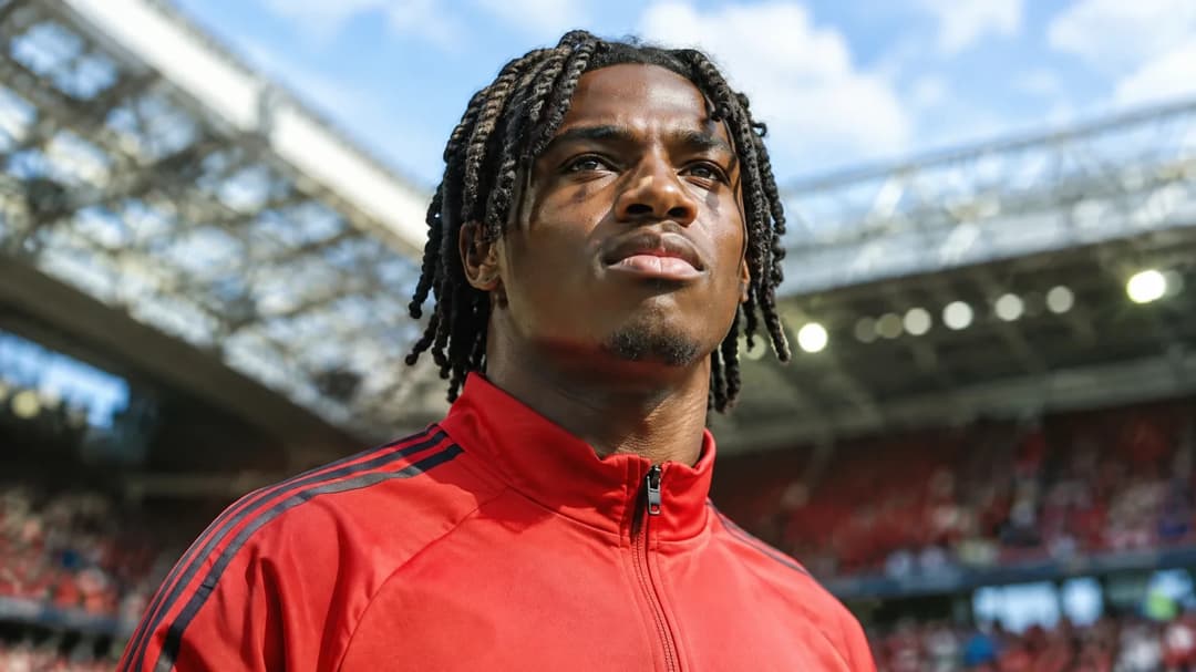 Isaac Konde stands confidently at Old Trafford, showcasing his determination during his transfer announcement.