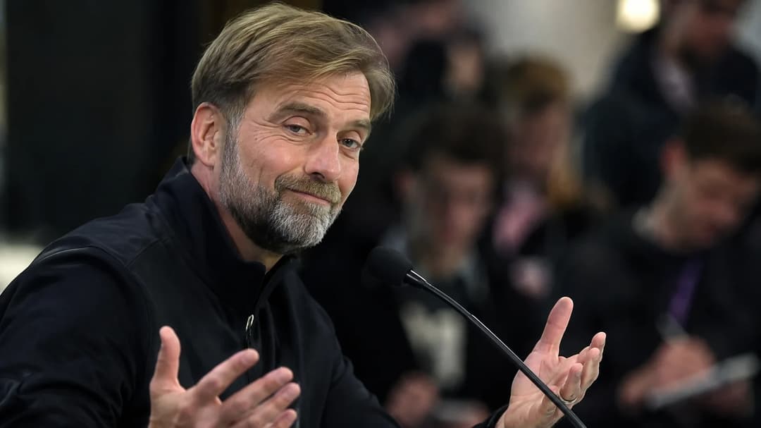 Jürgen Klopp speaks during a press conference, showing confidence and focus.