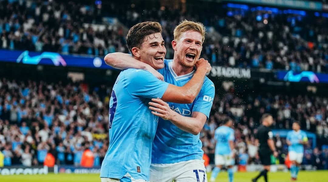 To spillende Manchester City-spillere feirer et mål med intense ansiktsuttrykk.