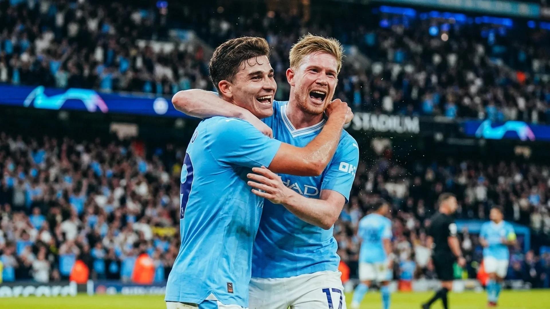 To spillende Manchester City-spillere feirer et mål med intense ansiktsuttrykk.