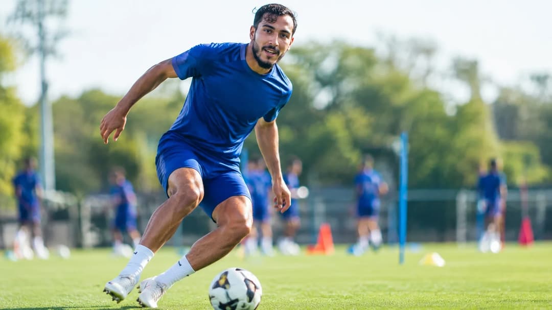 Rayan Cherki practicing soccer on a training pitch.
