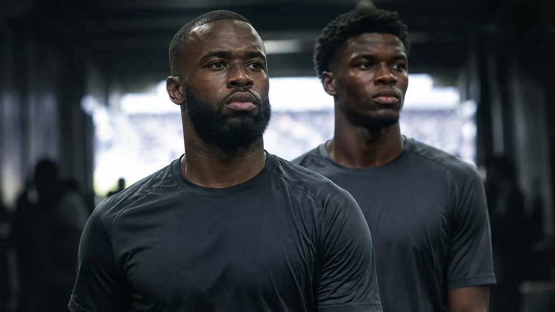 Lutsharel Geertruida og Xavier Mbuyamba står sammen i et svakt opplyst stadionmiljø.