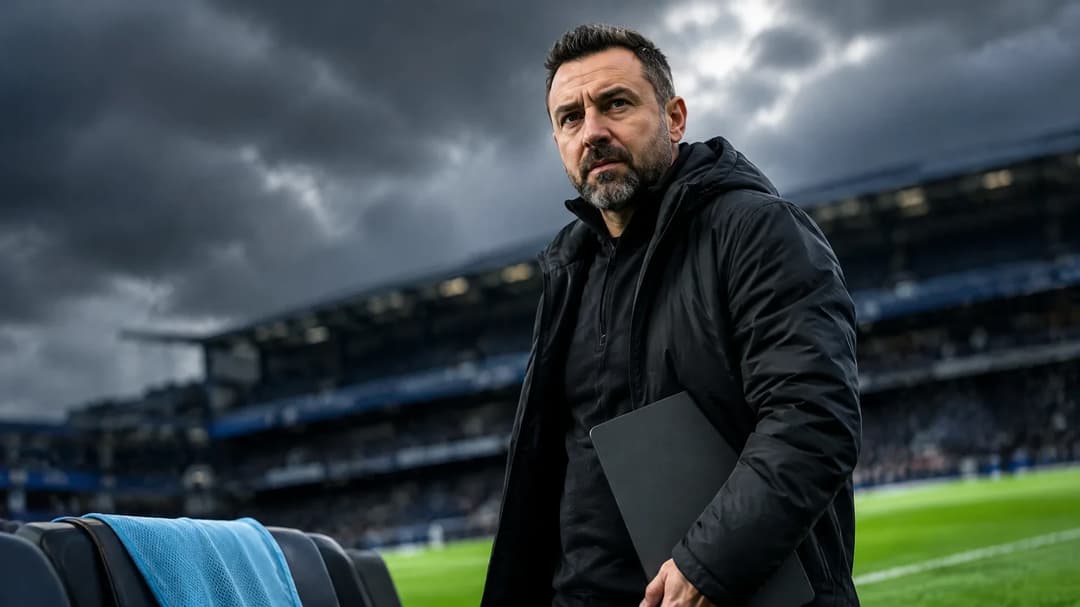 Roberto De Zerbi står konsentrert ved sidelinjen under mørke stormskyer, med en tom treningsvest på benken i forgrunnen.