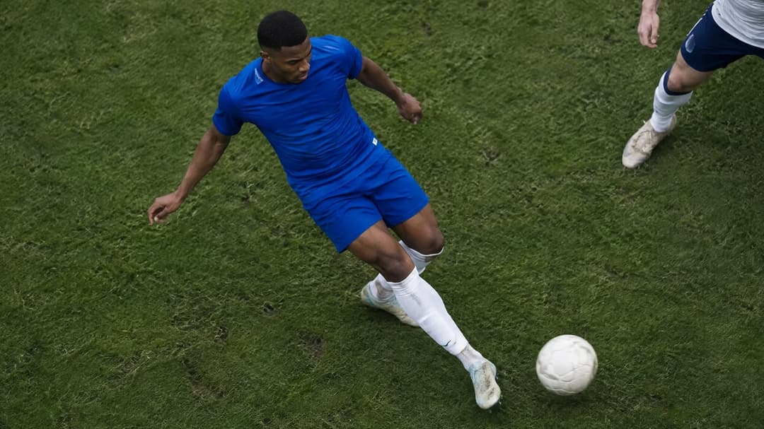Chelsea-forsvarer Jorrel Hato forsøker å bryte en pasning under press fra en Tottenham-spiller.