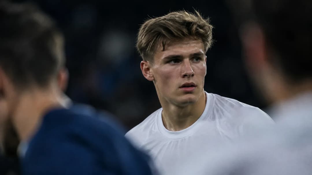 Finn Jeltsch står konsentrert på banen, omgitt av uskarpe spillere og tilskuere.