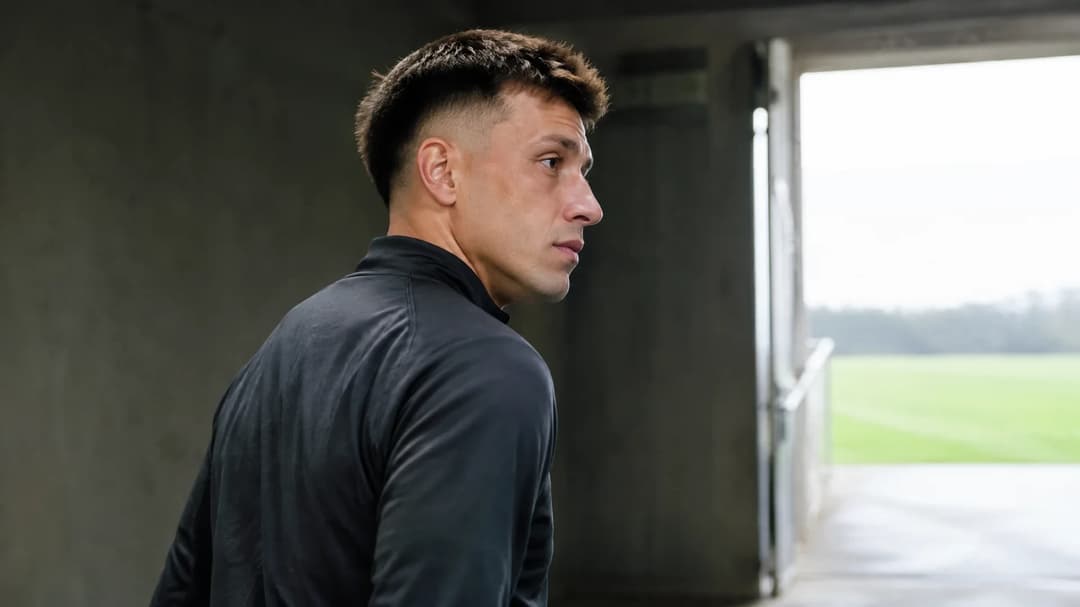 Lisandro Martínez går gjennom en stadionpassasje mot dagslyset, iført en nøytral treningsgenser.
