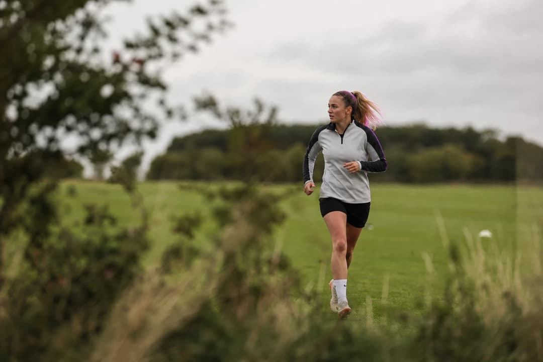 Welsh footballer Phoebie Poole trains on a grass pitch in overcast conditions, captured during her first days with her new club.