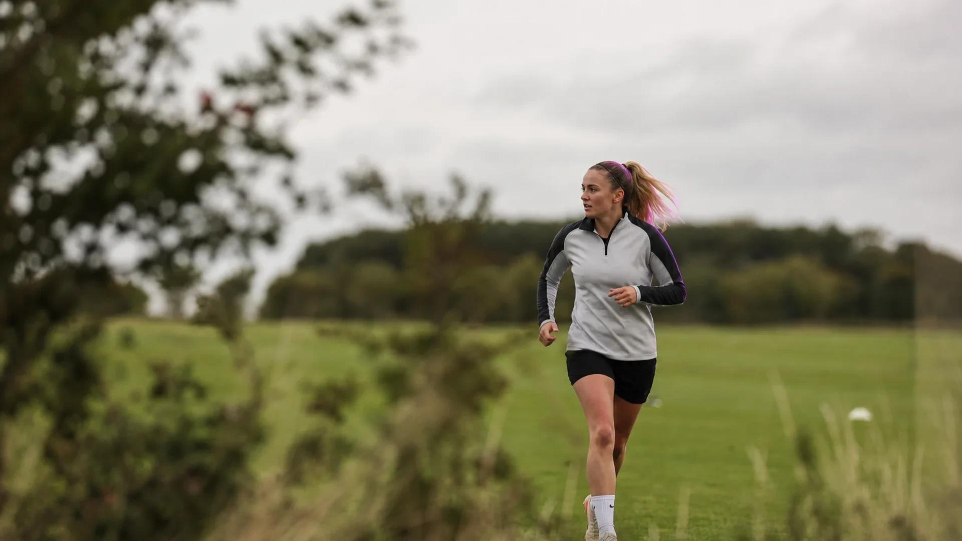 Welsh footballer Phoebie Poole trains on a grass pitch in overcast conditions, captured during her first days with her new club.