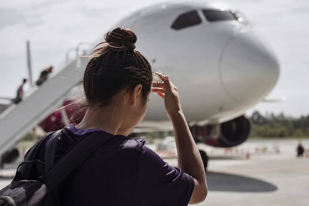 Women’s football player adjusting her hair as the FC Bayern München team arrives at the airport.