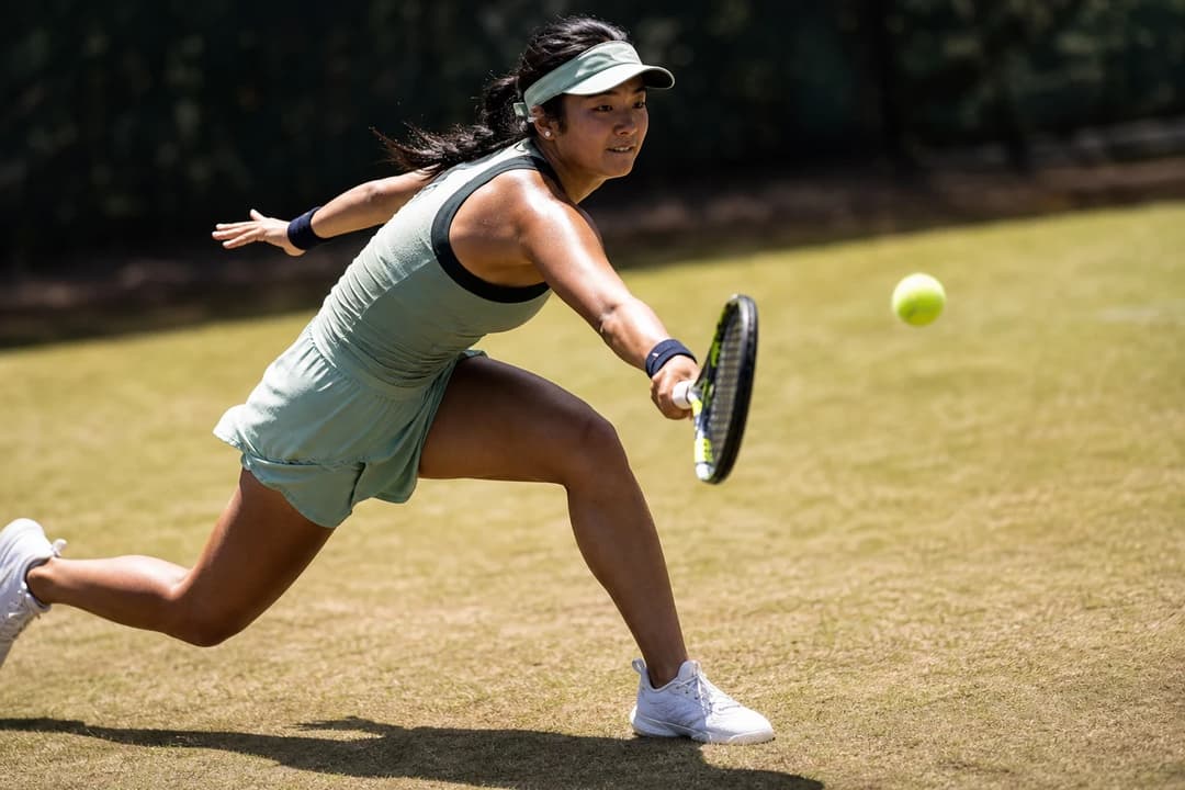 Alexandra Eala in action on the tennis court, captured from a low angle.