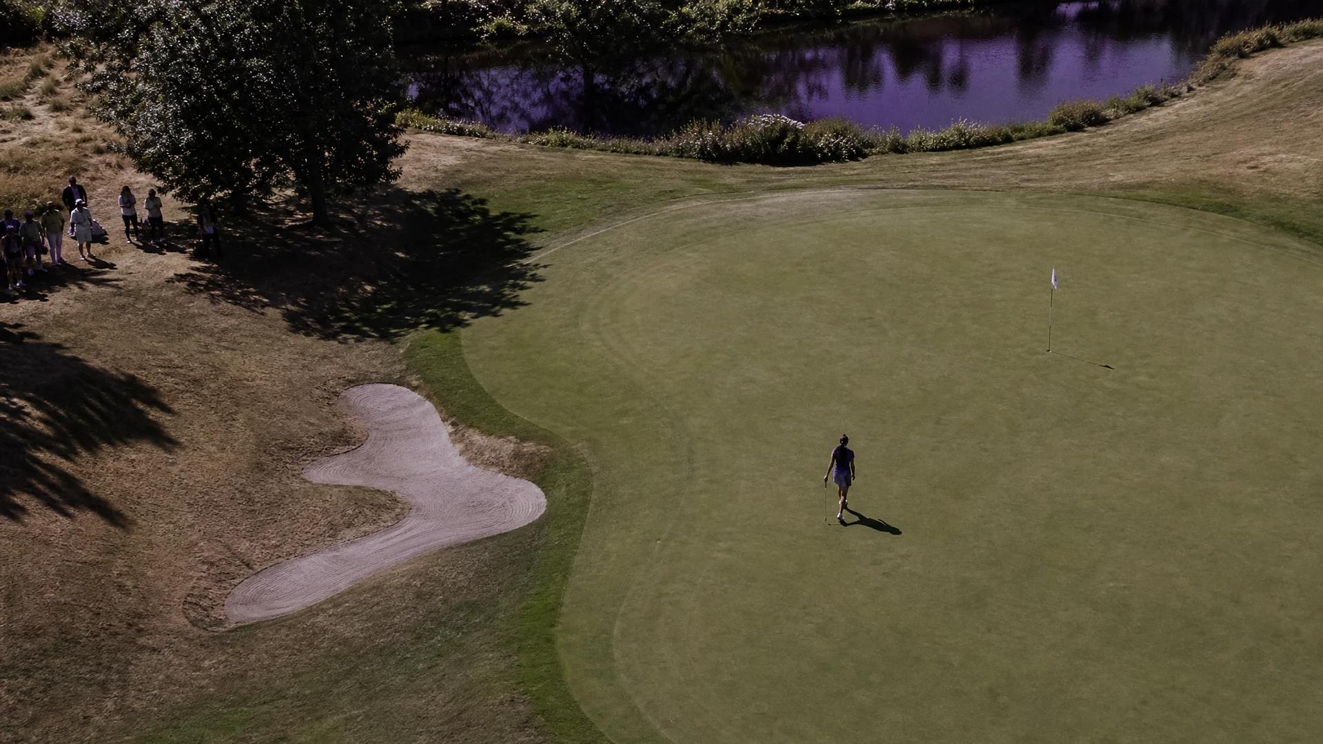 A bird's-eye view of a golf course with Jenny Shin approaching the 18th hole, highlighting her triumph in the Women's Scottish Open.
