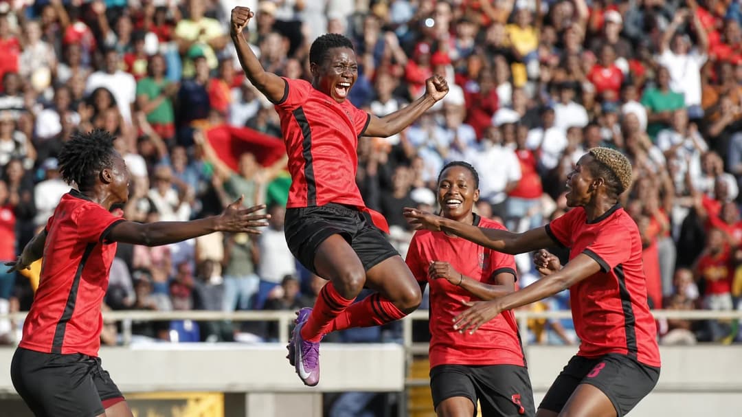 Temwa Chawinga celebrates a goal during a match at WAFCON, surrounded by teammates.