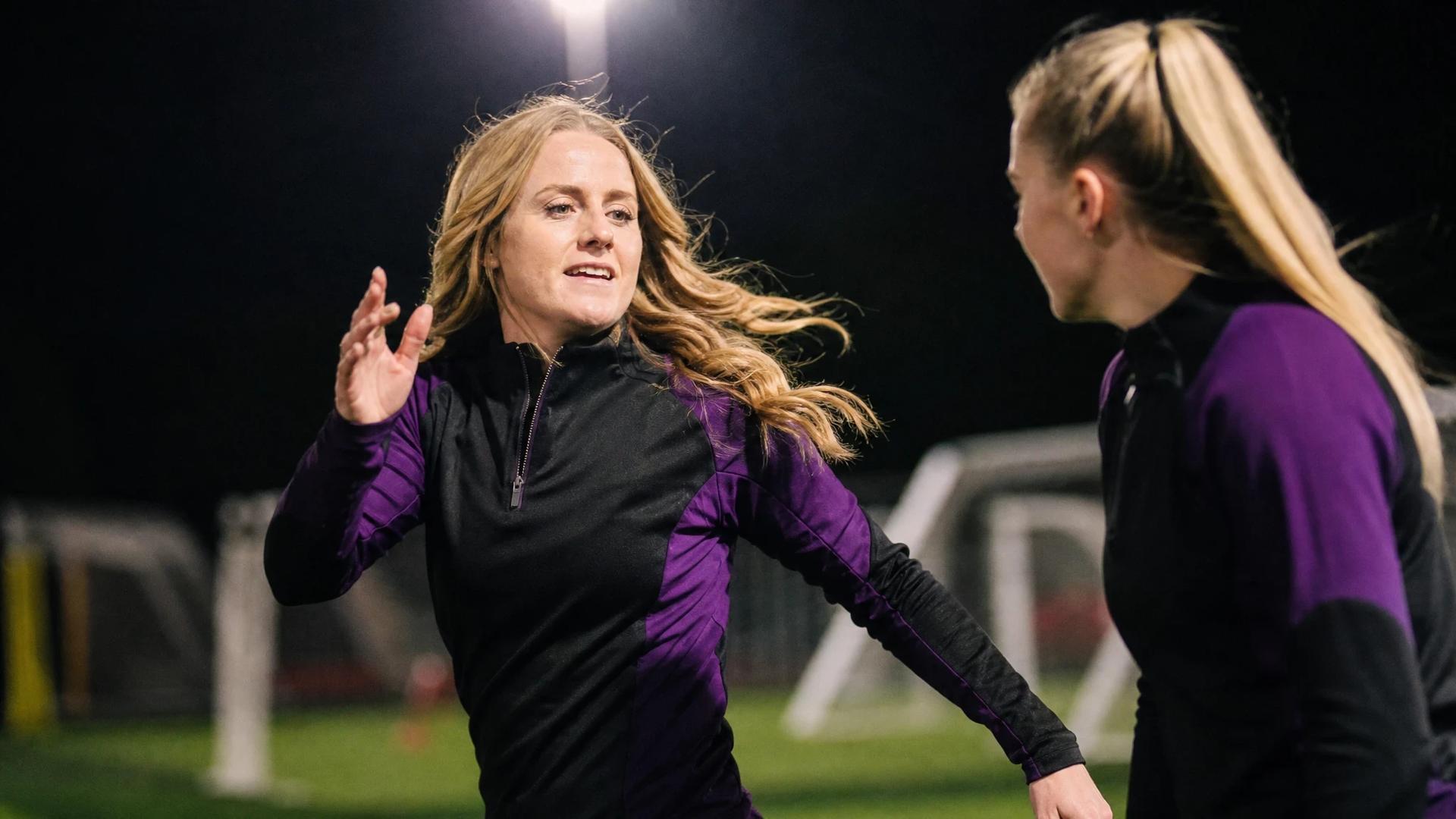 Mollie Rouse and a teammate interact energetically during training.