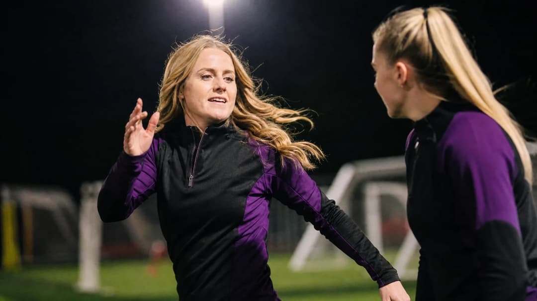 Mollie Rouse and a teammate interact energetically during training.
